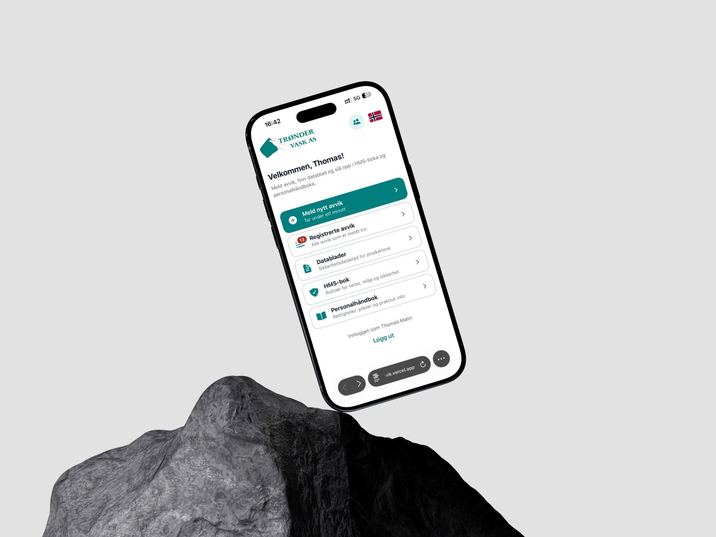 Avvikssystemet til Trøndervask AS vist på en mobil over en stein